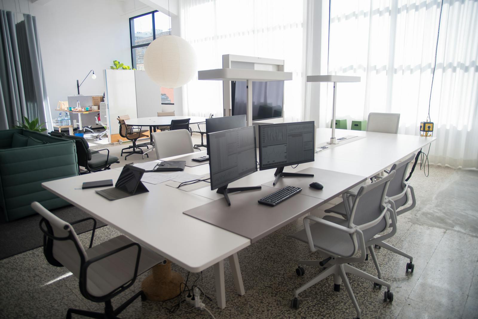 Spacious and organized open office workspace with modern furniture and natural lighting.